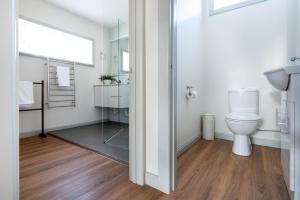 a bathroom with a toilet and a mirror at Bluebell Cottage in Invermay