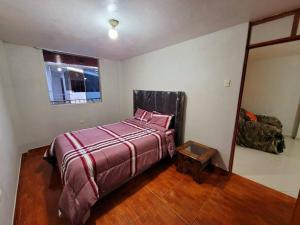 a bedroom with a large bed and a mirror at Amplio Departamento Amoblado de Estreno in Cajamarca