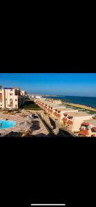 a view of a beach with buildings and the ocean at La sirena double room with mountain view, Families and couples only, Extra of 180 Egyptian pounds per adult person per stay ,to be paid to the resort in Ain Sokhna