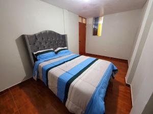 a bedroom with a bed with blue and white sheets at Amplio Departamento Amoblado de Estreno in Cajamarca