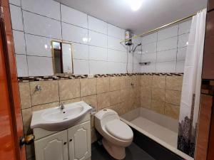 y baño con aseo, lavabo y bañera. en Amplio Departamento Amoblado de Estreno, en Cajamarca