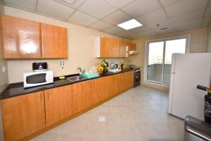 - une cuisine avec des placards en bois et un réfrigérateur blanc dans l'établissement شقق فندقية, à Dubaï