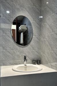 a bathroom with a sink and a mirror at Han Riverine Hotel & Cafeteria DaNang in Danang