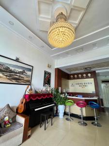un soggiorno con pianoforte e sgabelli di Dang Uyen 1 Hotel a Da Lat