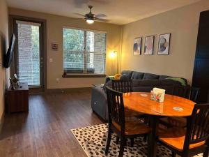 uma sala de estar com uma mesa e um sofá em Elite Retreat in Addison Circle em Addison