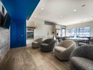 a living room with chairs and a kitchen with a table at Elite Retreat in Addison Circle in Addison