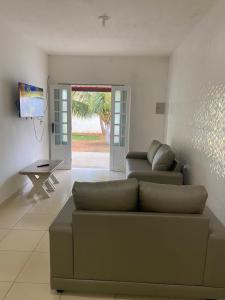 a living room with a couch and a sliding glass door at Residencial Sauaçhuy in Ipioca