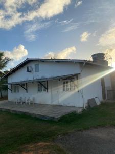 a white house with a group of chairs in front of it at Residencial Sauaçhuy in Ipioca