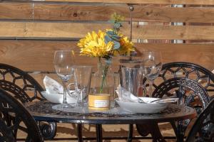 a table with glasses and a vase with flowers on it at The Seashells Whitstable in Kent