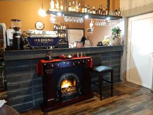 a bar with a fireplace and a bar stool at Complex Dalex in Drăgăşani