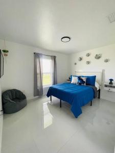 1 dormitorio con 1 cama azul y 1 sofá en White house 1, en Lehigh Acres