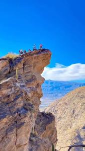 a group of people standing on top of a cliff at Río de Chocolate in Santa María