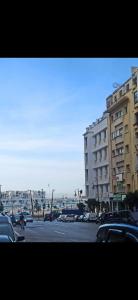 una calle de la ciudad con coches estacionados frente a los edificios en appartement marina bay, en Tánger