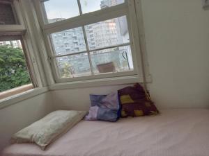 Tempat tidur dalam kamar di Quarto compartilhado 2 camas solteiro Centro POA