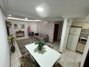 a kitchen and living room with a table and a couch at Apto 2D Capão da Canoa/Praça Flávio 150m Mar in Capão da Canoa