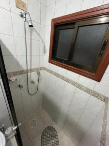 a bathroom with a shower with a window at Apto 2D Capão da Canoa/Praça Flávio 150m Mar in Capão da Canoa