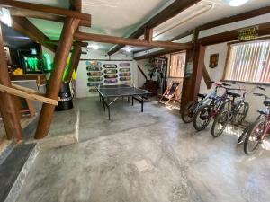 a room with a ping pong table and bikes in it at Tree Park Cambury in Camburi