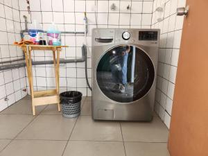 a boy standing in a washing machine in a bathroom at Alojamiento San Francisco Preciosas habitaciones con baño privado in Lima