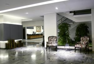 a lobby with two chairs and a table in a building at Antonio´s Palace Hotel in Piracicaba