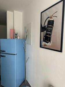 a blue refrigerator in a kitchen with a picture on the wall at Deluxe Apartement mit Terrasse in Duisburg