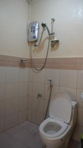 a bathroom with a toilet and a shower at CG'S TRAVELLERS INN in Panglao