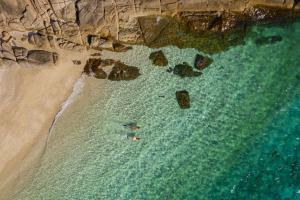two people swimming in the water at the beach at Six Senses Con Dao - Turtle Island Paradise in Con Dao