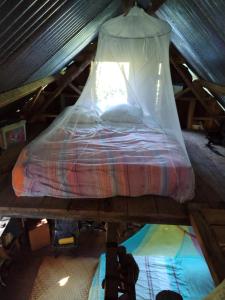 a bed with a canopy in a attic at Ilet Foukènwar in Saint-Louis