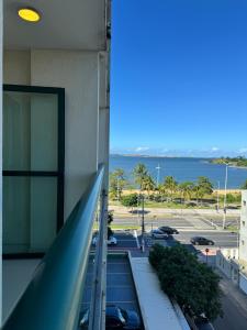 een balkon van een gebouw met uitzicht op een parkeerplaats bij Loft em frente à Praia in Vitória