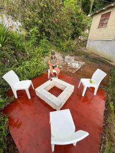 a person sitting in a chair around a fire pit at Adella's Blue Mountain Coffee Farmstay in Kingston