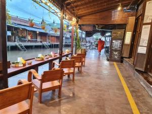 uma fila de mesas e cadeiras num restaurante em Thanicha Resort Amphawa em Amphawa