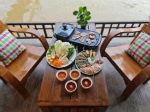 una mesa con varios platos de comida. en Thanicha Resort Amphawa, en Amphawa