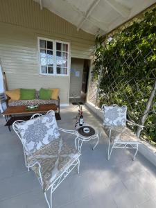 a patio with two chairs and a table and a couch at Adella's Blue Mountain Coffee Farmstay in Kingston