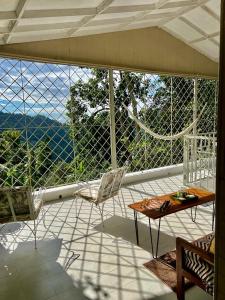 a porch with a table and chairs on a balcony at Adella's Blue Mountain Coffee Farmstay in Kingston