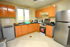 a kitchen with wooden cabinets and a stainless steel refrigerator at شقق فندقية in Dubai