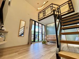 a loft bedroom with a bunk bed and a living room at Hualien Wazuka Homestay in Hualien City