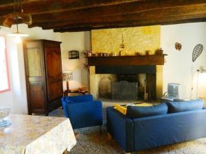 sala de estar con sofás azules y chimenea en Comfortable holiday home with garden, en Sainte-Croix-de-Beaumont