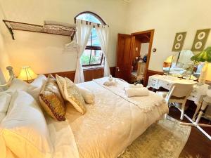 een slaapkamer met een bed, een bureau en een raam bij Tyalgum Bed & Breakfast - Celestial Dew in Tyalgum