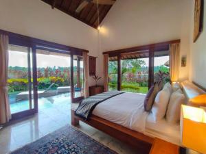 a bedroom with a bed with a view of a pool at Villa Maya Ubud, Peaceful Rice Field View in Ubud