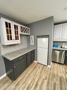 uma cozinha com armários brancos e um frigorífico branco em Downtown Sarasota House by Siesta Key and Pinecraft em Sarasota