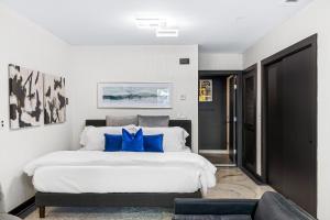 1 dormitorio con 1 cama blanca grande con almohadas azules en Hermetic Heart Of Midtown Semblance King Bed Studio, en Atlanta