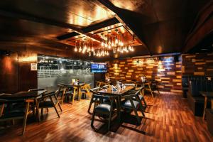 a restaurant with wooden floors and tables and chairs at Central Inn & Spa in Dhaka