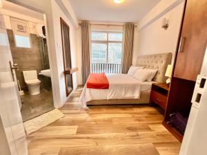 a bedroom with a bed and a bathroom at Lake View Residencies in Nuwara Eliya