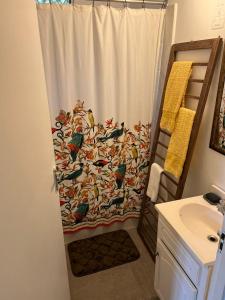 a shower curtain with birds on it in a bathroom at Adella's Blue Mountain Coffee Farmstay in Kingston