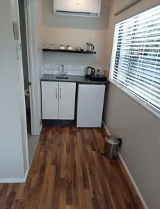 a kitchen with white cabinets and a wooden floor at Clyde on Naylor in Clyde