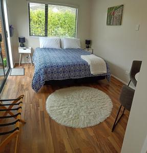 a bedroom with a bed and a rug on a wooden floor at Clyde on Naylor in Clyde