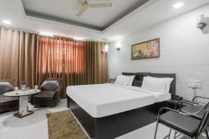 a bedroom with a large white bed and a chair at OYO The Casa Picolla in Bankipur