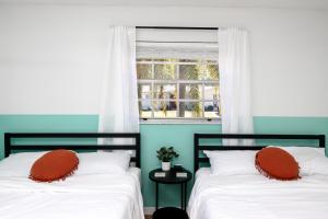 two beds in a room with a window at Sunny Escape: Vibrant Pool Home in Port Richey +11 photos