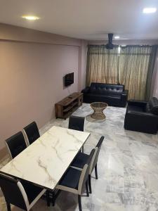 a living room with a table and chairs and a couch at GLORY BEACH 3 bedroom Seaview Resort-PRIVATE in Port Dickson