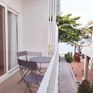 a balcony with a table and chairs and the ocean at Baanfah Resort Samui in Mae Nam