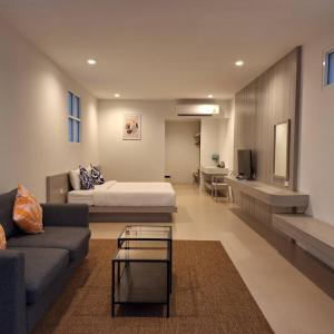 Baanfah Resort Samui في شاطئ مينام: غرفة معيشة مع سرير وأريكة